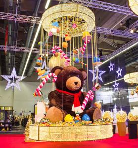 Bilbor the Bear is surrounded by whimsical sweets and the twinkly lights of Waterloo Rings and Stars