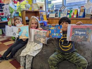Children hold up books that were purchased with a community grant from Sonoma County Vintners Foundation