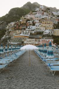 Photography of The Janeiro white beach umbrella standing out from regular umbrellas. 