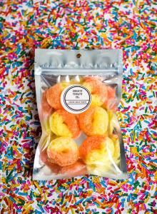 Gummy rings in a sealed bag with sprinkles in the background